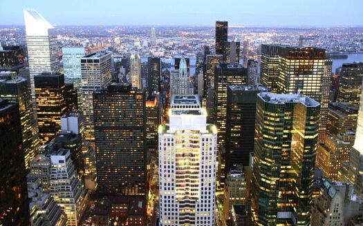 Panoramic view of the London financial district skyline at dusk, with modern skyscrapers, representing a hub of economic activity.