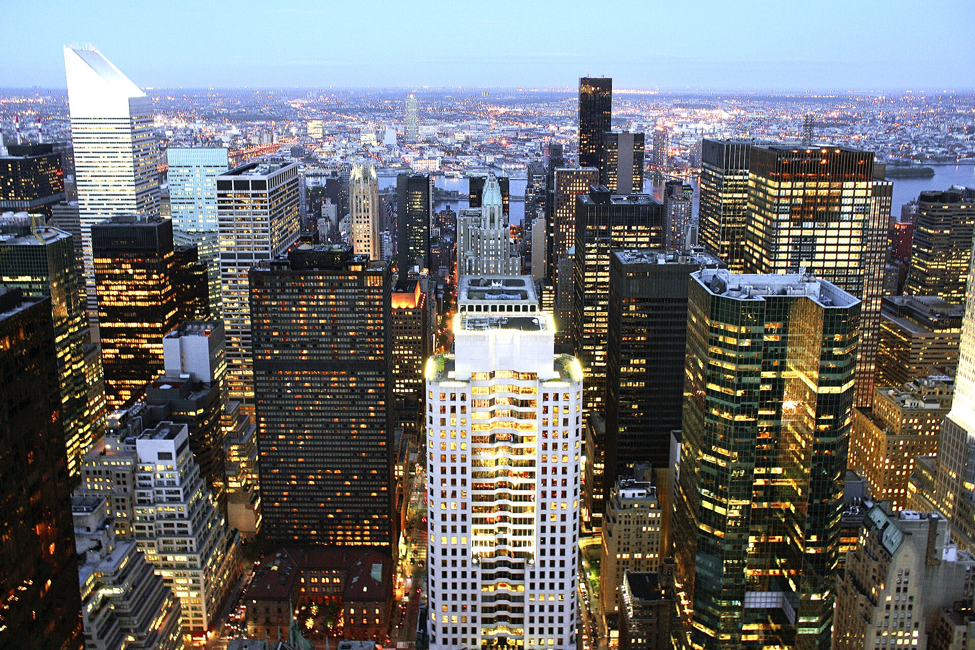 Panoramic view of the London financial district skyline at dusk, with modern skyscrapers, representing a hub of economic activity.