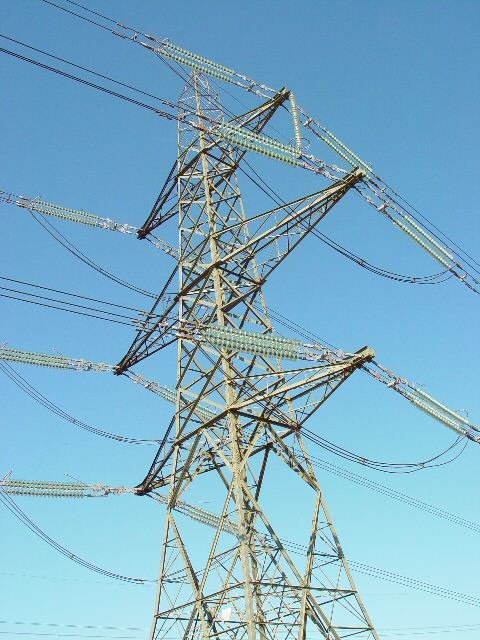 Electricity pylons crossing land near industrial development