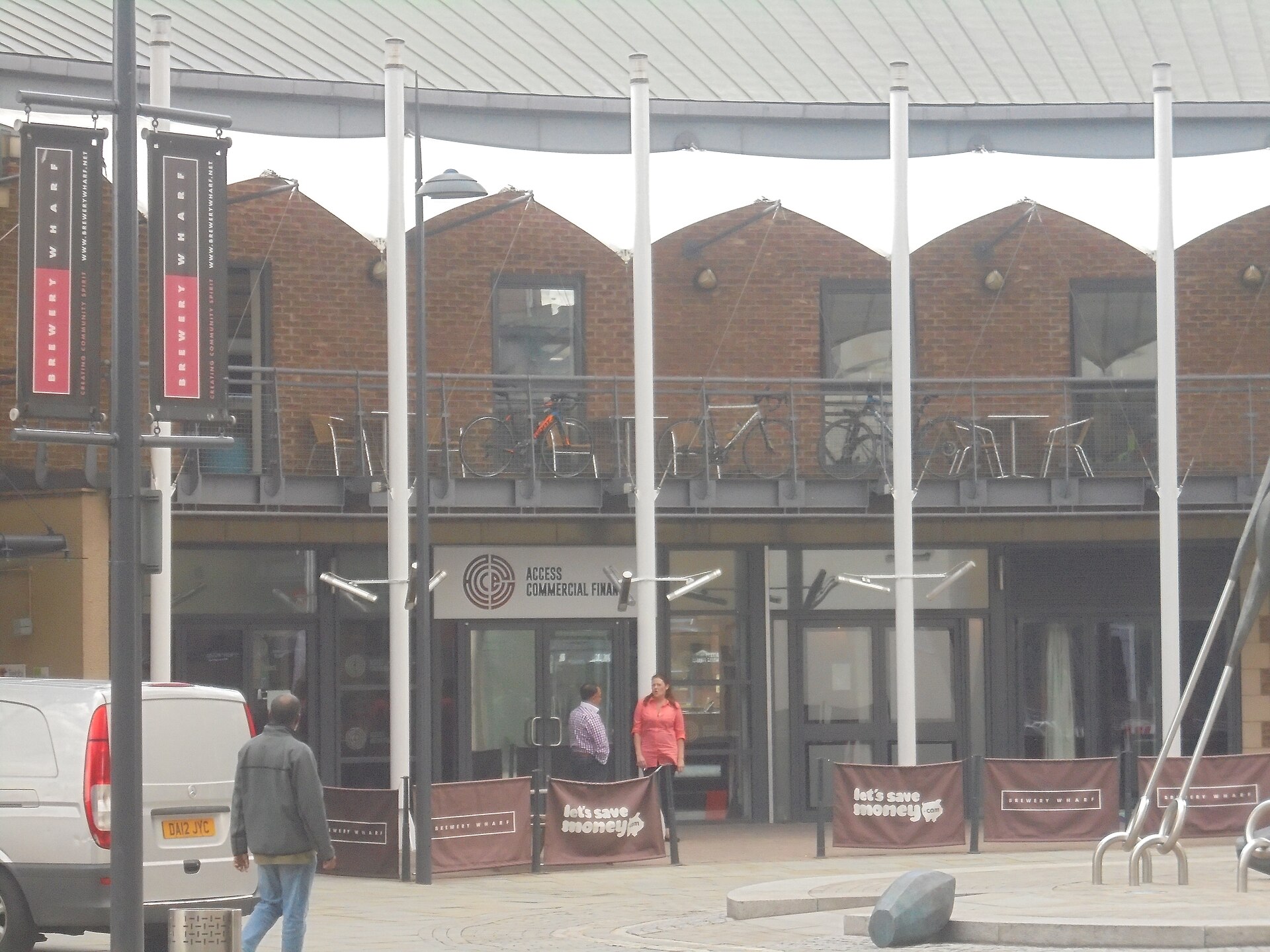 Contemporary commercial buildings along Leeds waterfront with pedestrians beside the canal