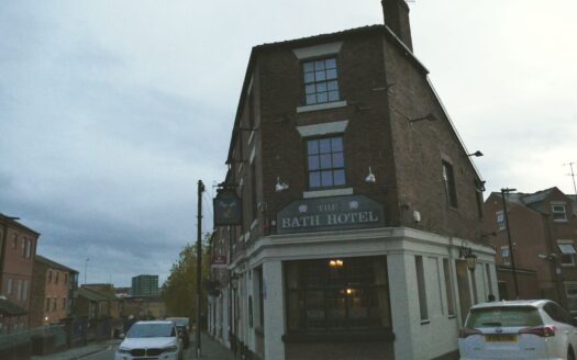 Contemporary hotel exterior on a busy UK city street at dusk