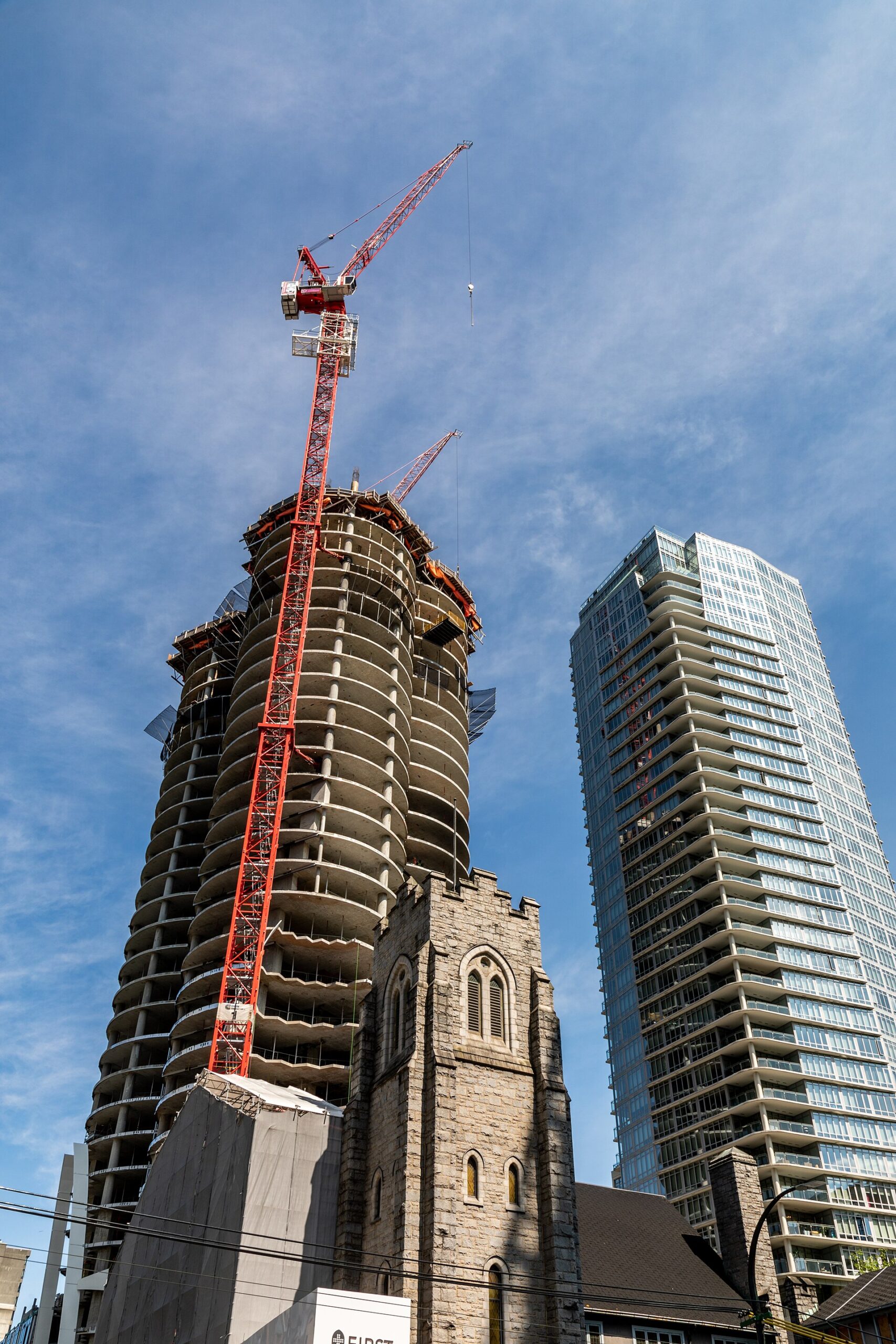 Completed apartment block beside an active residential construction site