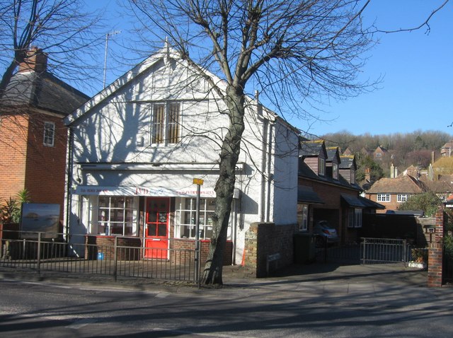 Residential street with estate agent windows and terraced homes